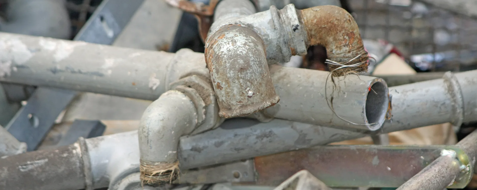 Old pipes laying in a pile, including lead pipes