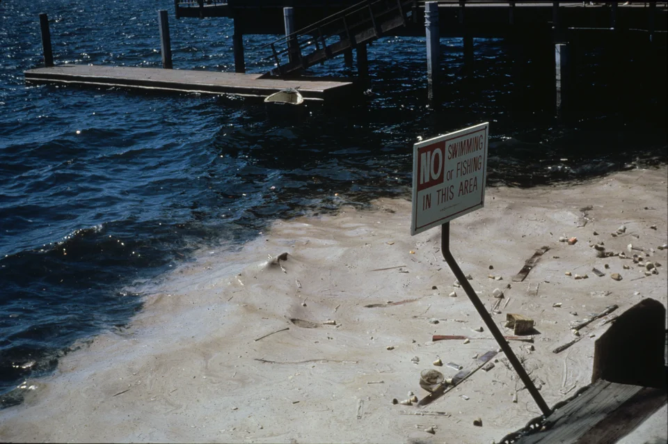 A 'No Swimming or Fishing' sign at a polluted San Diego Bay dock, 1968